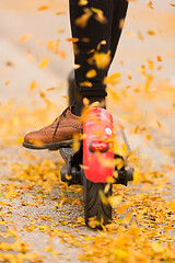 Image showing Detail of fashinable hipster girl riding electric scooter in park at fall