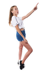 Image showing Full length of surprised teen girl pointing to side at blank copy space