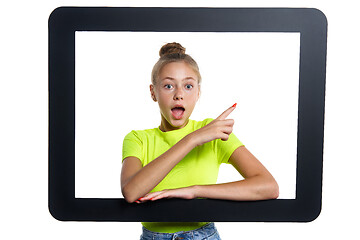Image showing Teen girl looking through digital tablet frame pointing finger to side