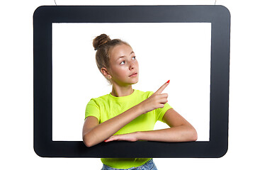 Image showing Teen girl looking through digital tablet frame pointing finger to side