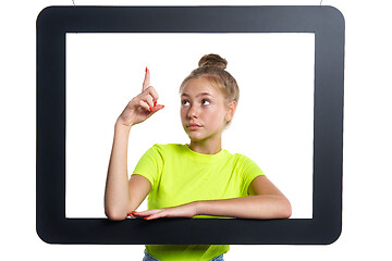 Image showing Teen girl looking through digital tablet frame pointing finger up