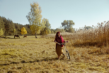 Image showing Pretty girl riding bicycle in field