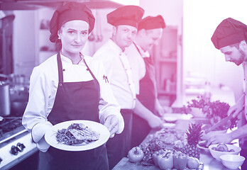 Image showing Chef holding dish of fried Salmon fish fillet