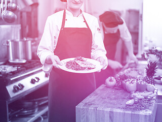 Image showing Chef holding dish of fried Salmon fish fillet