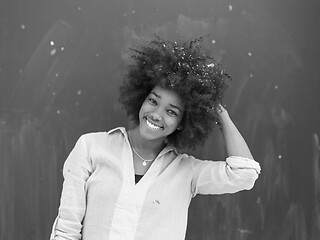 Image showing black woman blowing confetti in the air