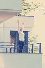 Image showing woman stretching her arms on balcony