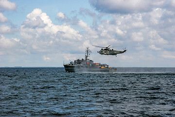 Image showing NATO rescue mission in sea with ship and helicopter.