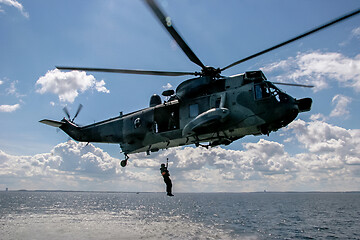 Image showing NATO rescue mission in sea with helicopter.