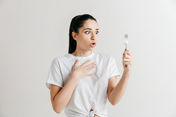 Image showing Young fun crazy brunette housewife with fork isolated on white background