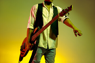Image showing African American handsome jazz musician holding bass guitar and welcomes the audience.