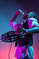 Image showing African American handsome jazz musician playing tambourine and singing.