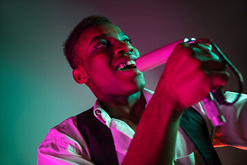 Image showing African American handsome jazz musician singing.