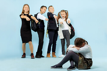 Image showing Little girl sitting alone on floor and suffering an act of bullying.