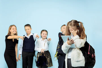 Image showing Little girl standing alone and suffering an act of bullying.