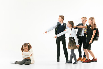 Image showing Little girl sitting alone on floor and suffering an act of bullying.