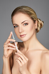 Image showing beautiful girl holding syringe