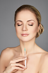 Image showing beautiful girl holding syringe