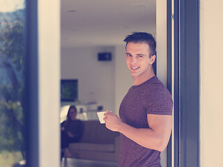 Image showing man drinking coffee in front of her luxury home villa