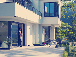 Image showing man drinking coffee in front of her luxury home villa