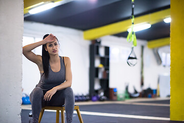 Image showing young athlete woman sitting and relaxing