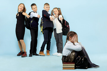 Image showing Little girl sitting alone on floor and suffering an act of bullying.