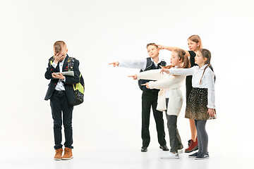 Image showing Little boy standing alone and suffering an act of bullying.