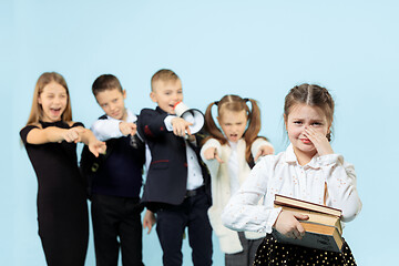 Image showing Little girl sitting alone on chair and suffering an act of bullying.