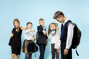 Image showing Little boy standing alone and suffering an act of bullying.