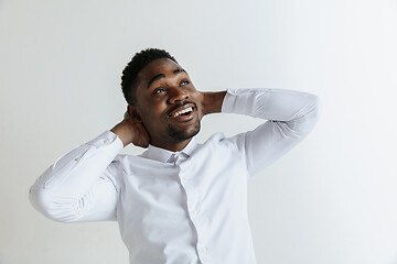 Image showing Close up portrait of a happy young african american man laughing against gray background.