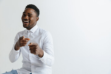 Image showing Afro american man over isolated grey background pointing with finger to the camera and to you, hand sign, positive and confident gesture from the front