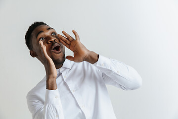 Image showing Wow. Attractive male half-length front portrait on grey studio backgroud. Young afro emotional surprised bearded man standing with open mouth. Human emotions, facial expression concept.