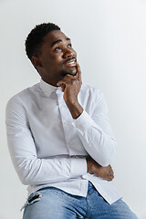 Image showing Close up portrait of a happy young african american man laughing against gray background.