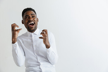 Image showing Wow. Attractive male half-length front portrait on grey studio backgroud. Young afro emotional surprised bearded man standing with open mouth. Human emotions, facial expression concept.