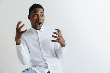 Image showing Wow. Attractive male half-length front portrait on grey studio backgroud. Young afro emotional surprised bearded man standing with open mouth. Human emotions, facial expression concept.