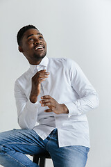 Image showing Close up portrait of a happy young african american man laughing against gray background.