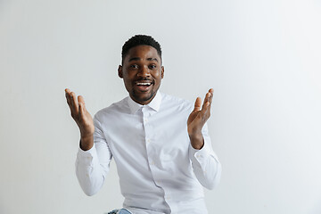 Image showing Wow. Attractive male half-length front portrait on grey studio backgroud. Young afro emotional surprised bearded man standing with open mouth. Human emotions, facial expression concept.