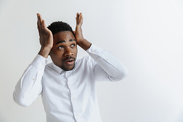 Image showing Closeup portrait of handsome young man shocked surprised, open mouth and eyes, mad by what he sees, isolated on grey background. Negative human emotion facial expression feeling concept.