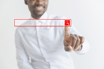 Image showing Young african american guy interacts with empty search bar. Negative space to insert your text.