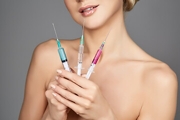 Image showing beautiful girl holding syringes