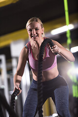 Image showing athlete woman doing battle ropes cross fitness exercise