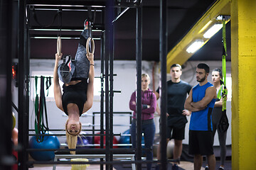 Image showing woman working out with personal trainer on gymnastic rings