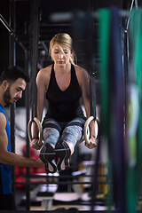 Image showing woman working out with personal trainer on gymnastic rings