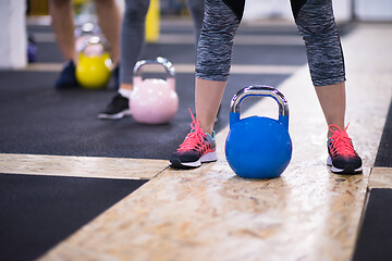 Image showing athletes doing exercises with kettlebells