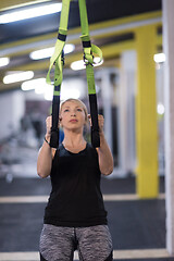 Image showing woman working out pull ups with gymnastic rings