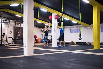 Image showing young athletes couple working out with medical ball