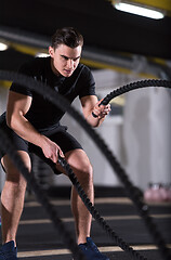 Image showing athlete man doing battle ropes cross fitness exercise