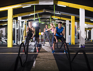 Image showing sports couple doing battle ropes cross fitness exercise