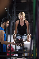 Image showing woman working out with personal trainer on gymnastic rings