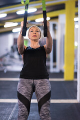 Image showing woman working out pull ups with gymnastic rings