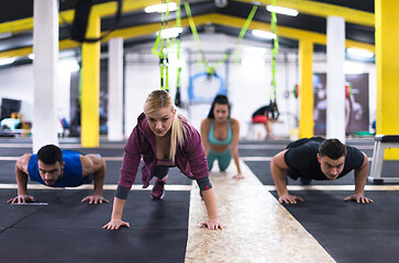 Image showing young healthy people doing pushups